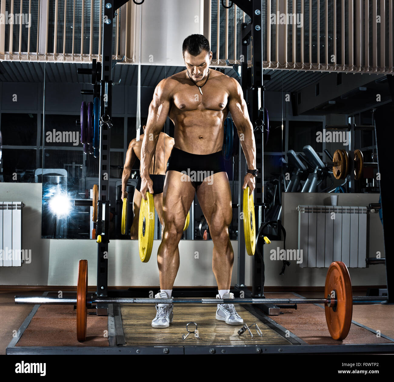 very brawny guy bodybuilder,  execute exercise with  weight Stock Photo