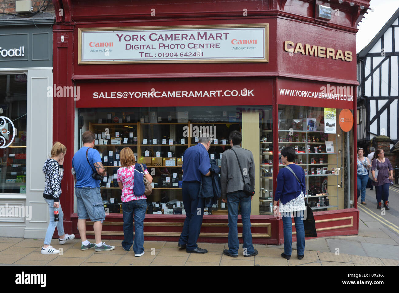 People window shopping, York Camera Mart shop exterior, York, England Stock Photo