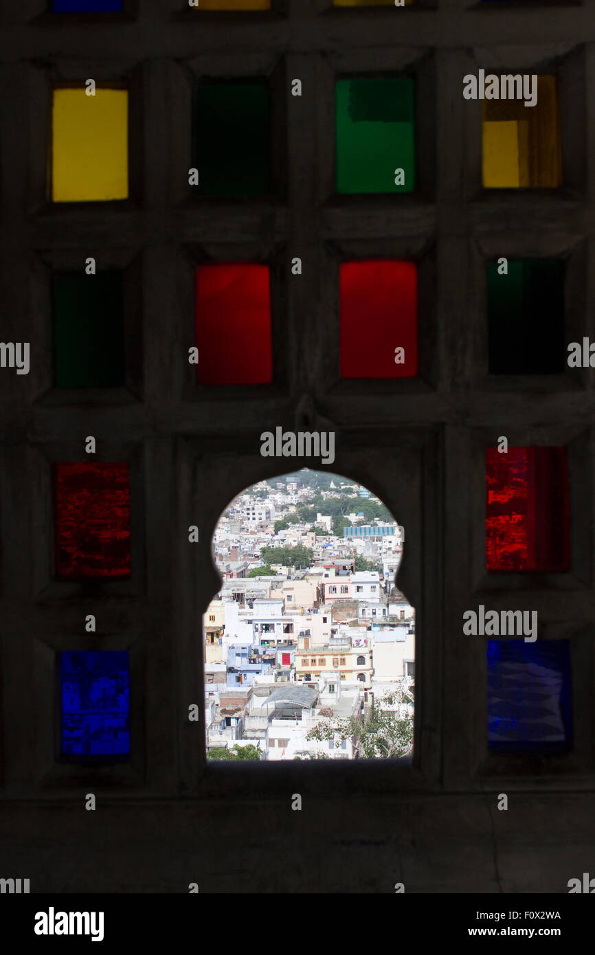 The city of Udaipur through the colorful window of the City Palace built in 1559 by Maharana Uday Singh , a symbol of Mevad Stock Photo