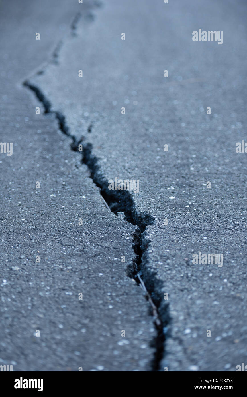 A long windy crack on a paved street. Stock Photo