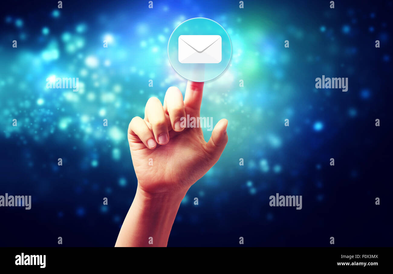 Hand pressing a envelope icon over technology blue background Stock Photo