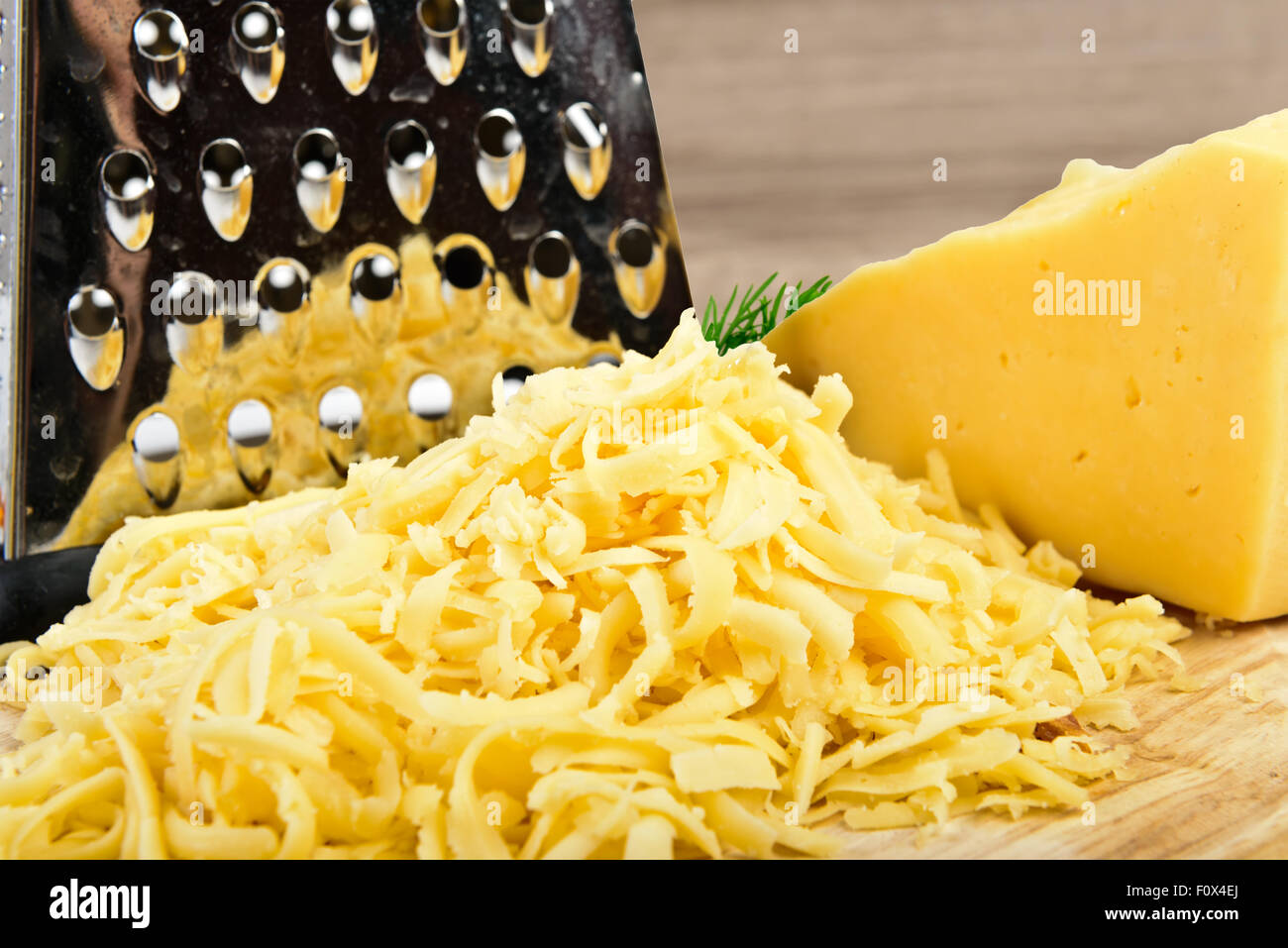 grated cheese on wooden board Stock Photo