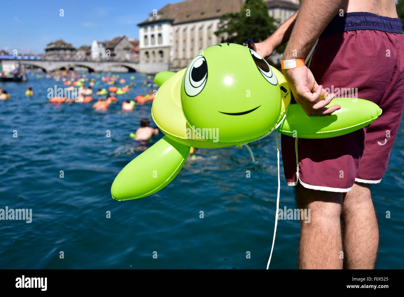 Zurich, Switzerland. 22nd August, 2015. A young woman is jumping into Zurich's cool Limmat river to drift down 2km through the city. Sunny weather and warm temperatures at Zurich's traditional 'Limmatschwimmen' ('swim down the Limmat river') attracted 4500 swimmers who, equipped with rubber turtles and other fancy floating devices, enjoyed drifting down the river through Zurich. Credit:  Erik Tham/Alamy Live News Stock Photo