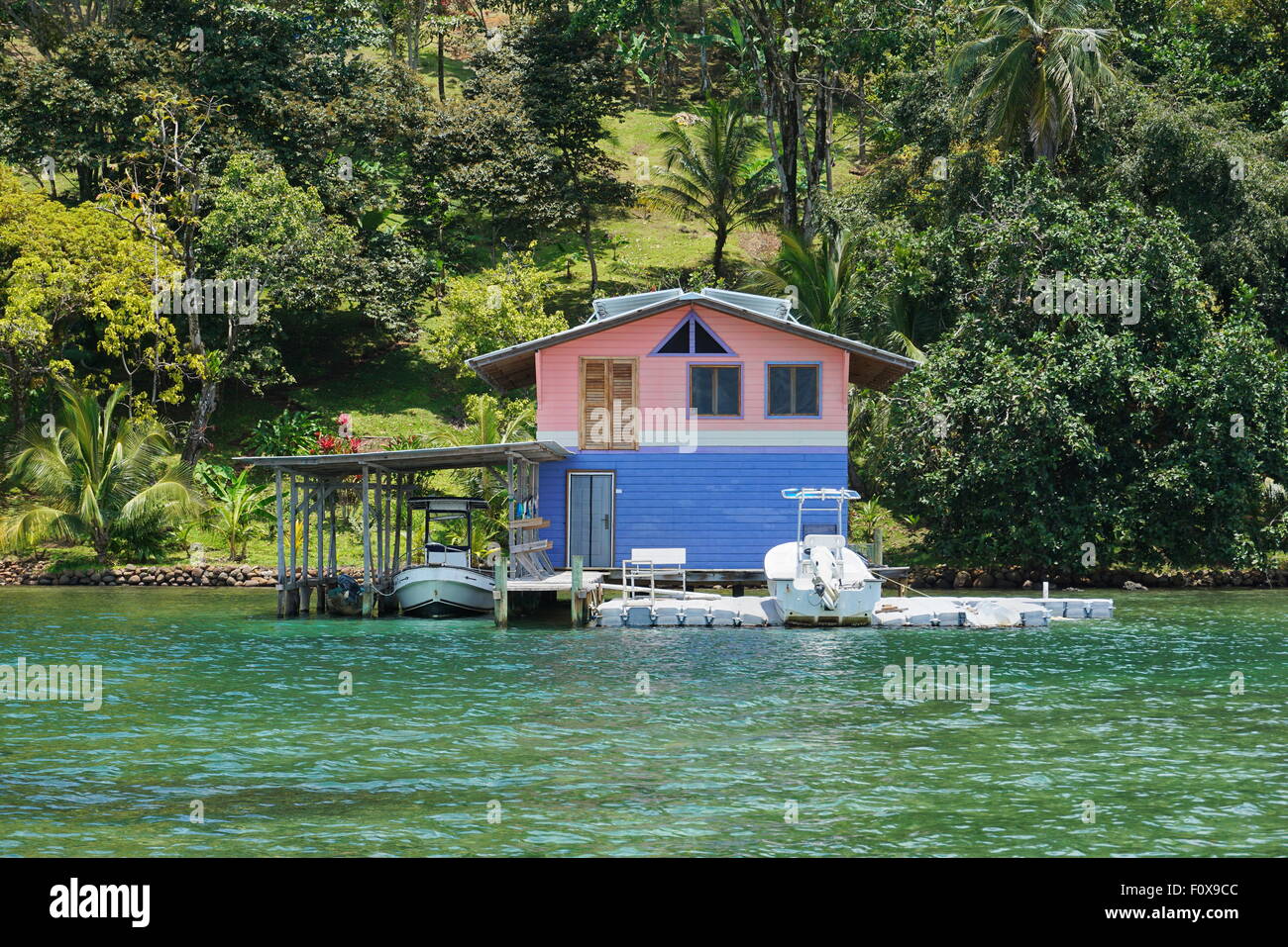 Coastal home with floating dock and boat house over water on the Caribbean shore of Panama, Central America Stock Photo