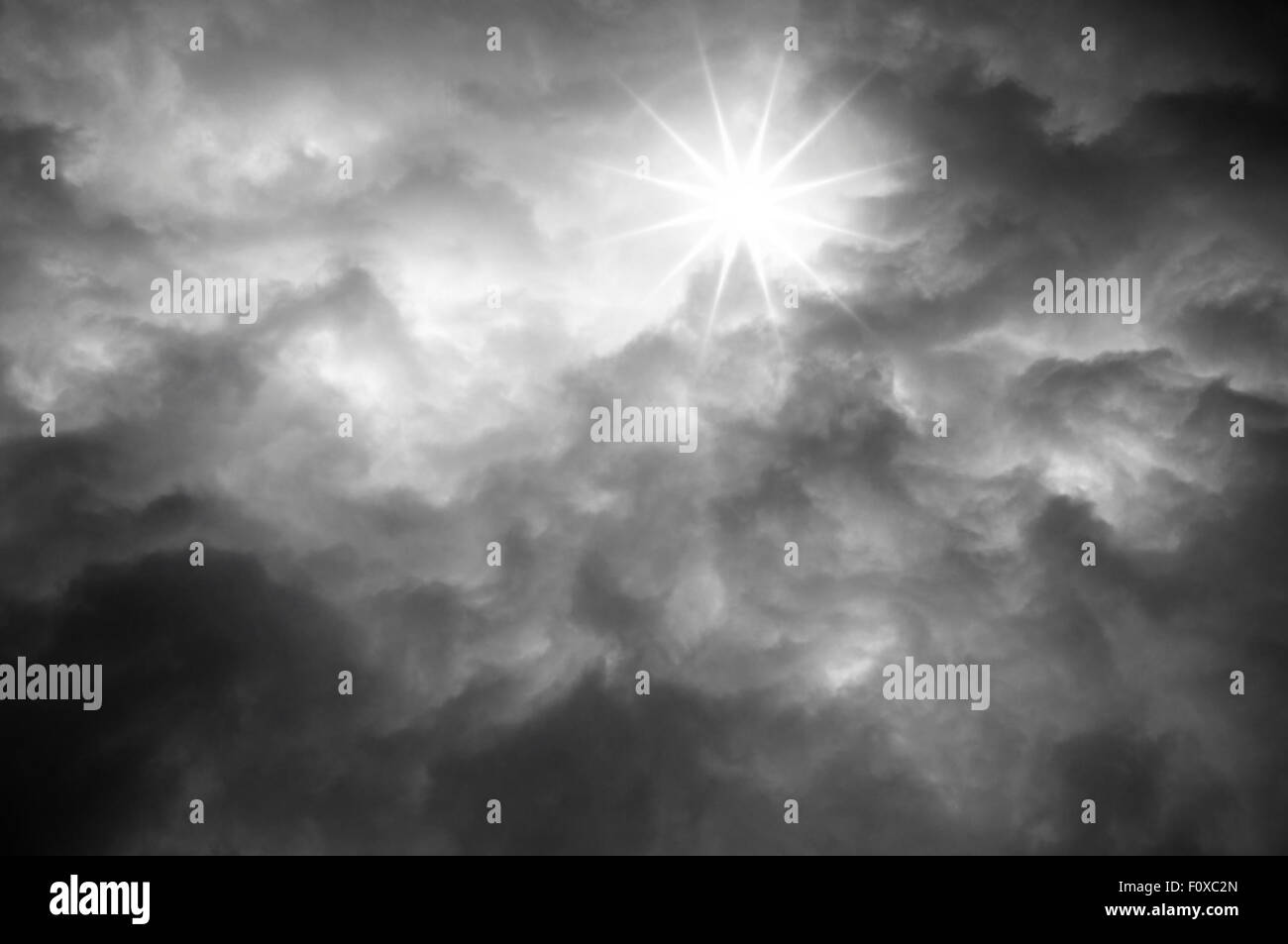 Sun shines from Dark clouds of storm sky Stock Photo