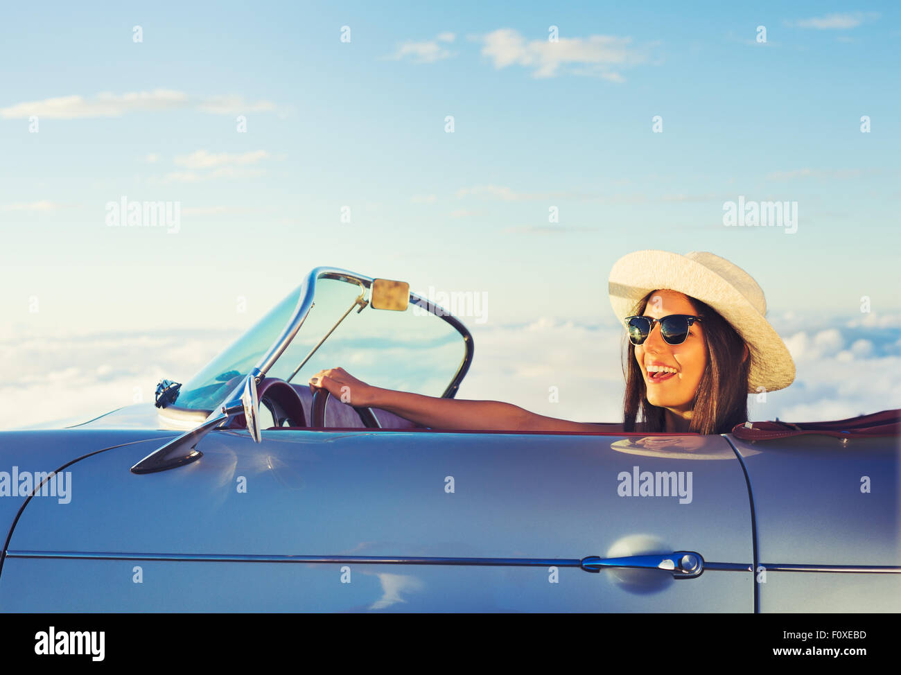 Happy Young Woman Driving in Classic Vintage Sports Car Stock Photo