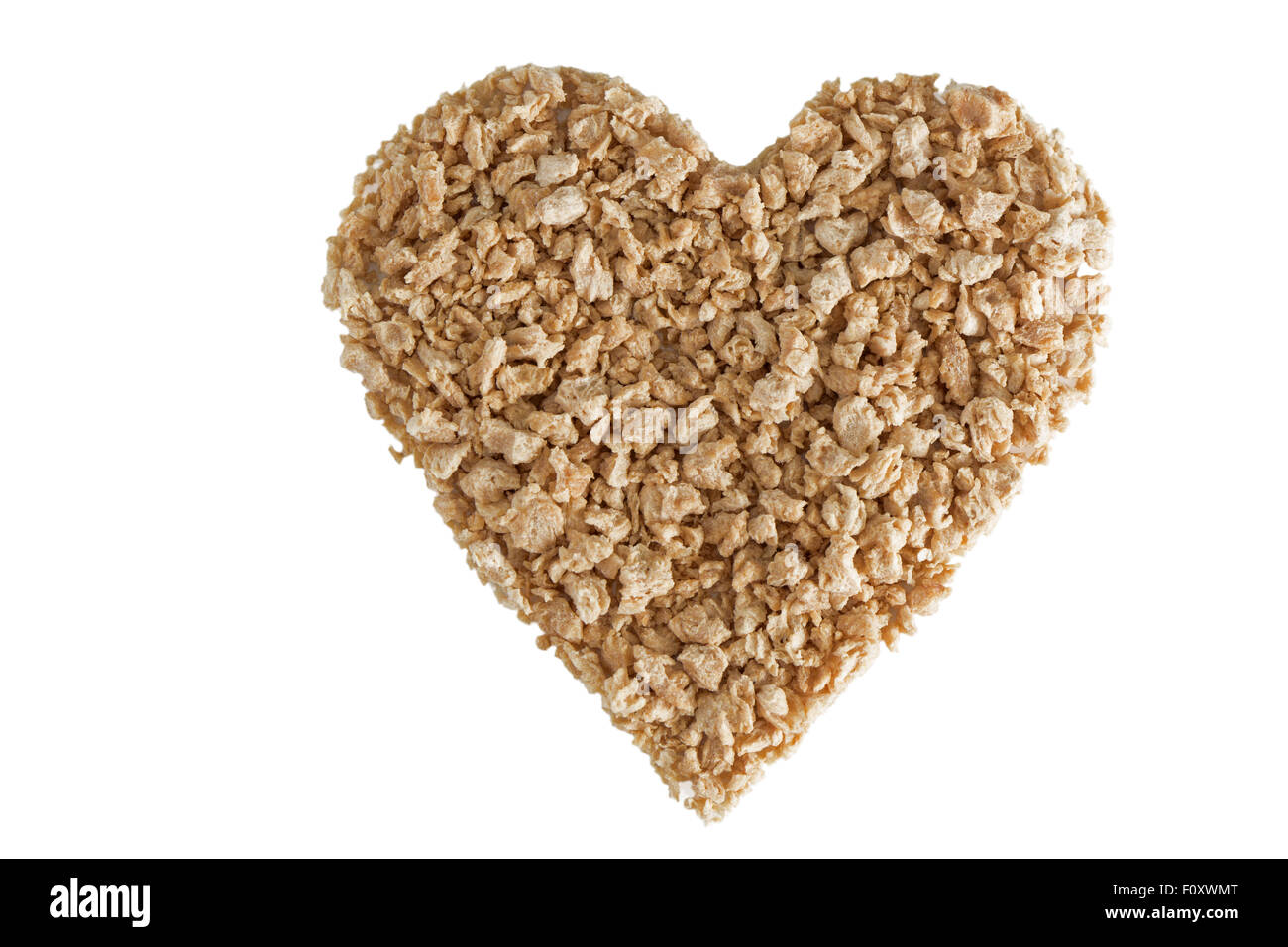 Heart shape made of textured soy protein granules viewed from above, isolated on white background. Stock Photo