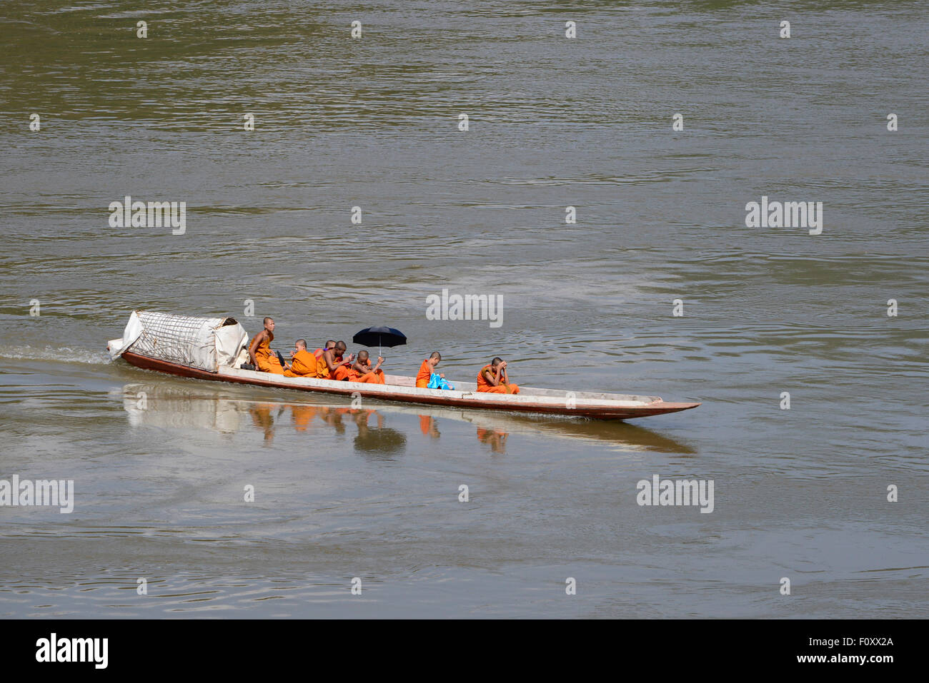 Buddhist monks crossing the river by boat Stock Photo