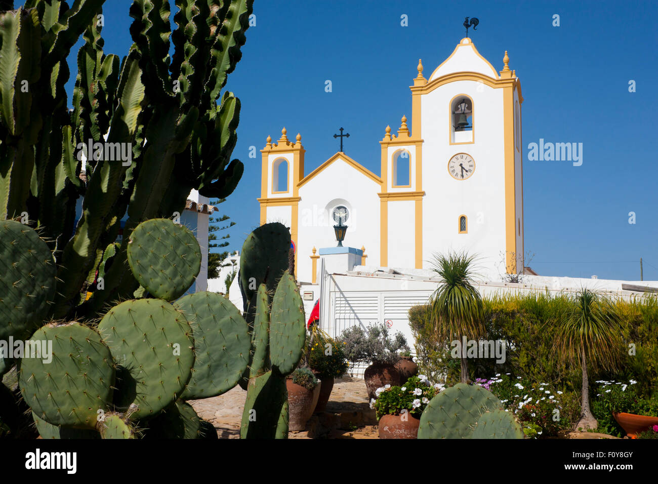 Praia da Luz church of Nossa Senhora da Luz Our Lady of Light with cactus plant in foreground Algarve Portugal Stock Photo