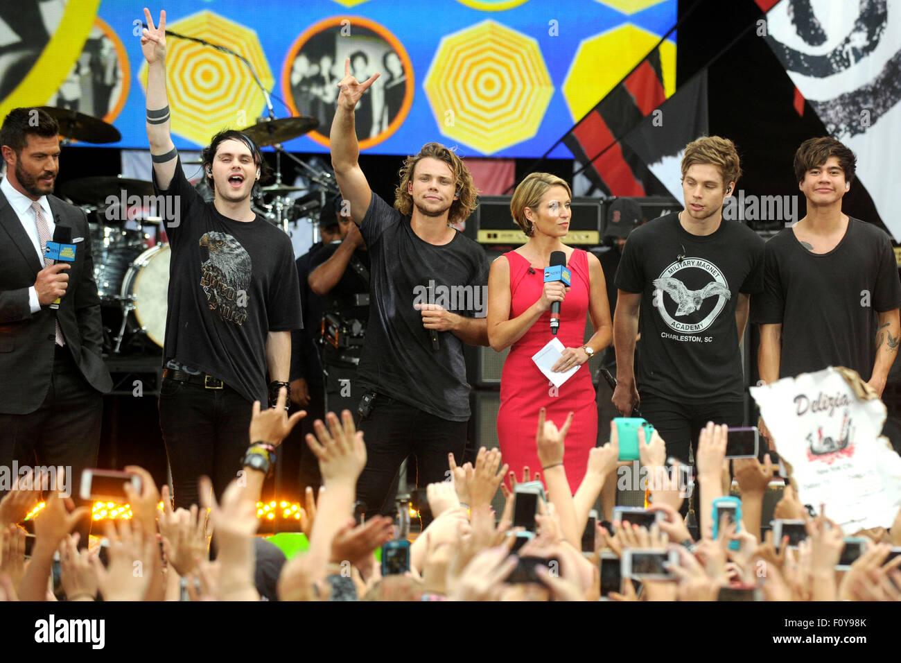 New York City. 21st Aug, 2015. ABC anchors Jesse Palmer(L) and Amy Robach(C) pose with Michael Clifford, Ashton Irwin, Luke Hemmings and Calum Hood of 5 Seconds Of Summer on ABC's 'Good Morning America' at Rumsey Playfield, Central Park on August 21, 2015 in New York City. © dpa/Alamy Live News Stock Photo