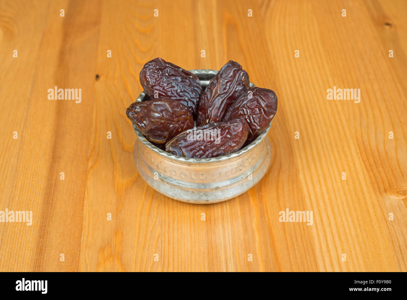 Bowl of dried dates on a wooden background Stock Photo - Alamy