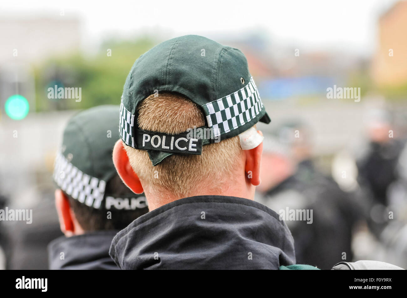 Police officers stand guard at a public event, wearing baseball caps. Stock Photo