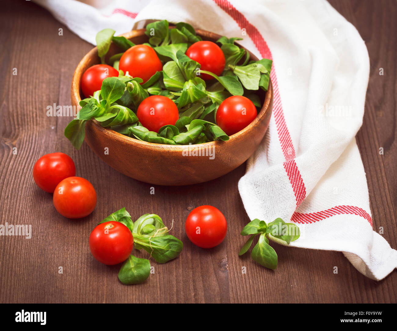 Summer salad with  lamb's lettuce and cherry tomatoes on wooden background Stock Photo