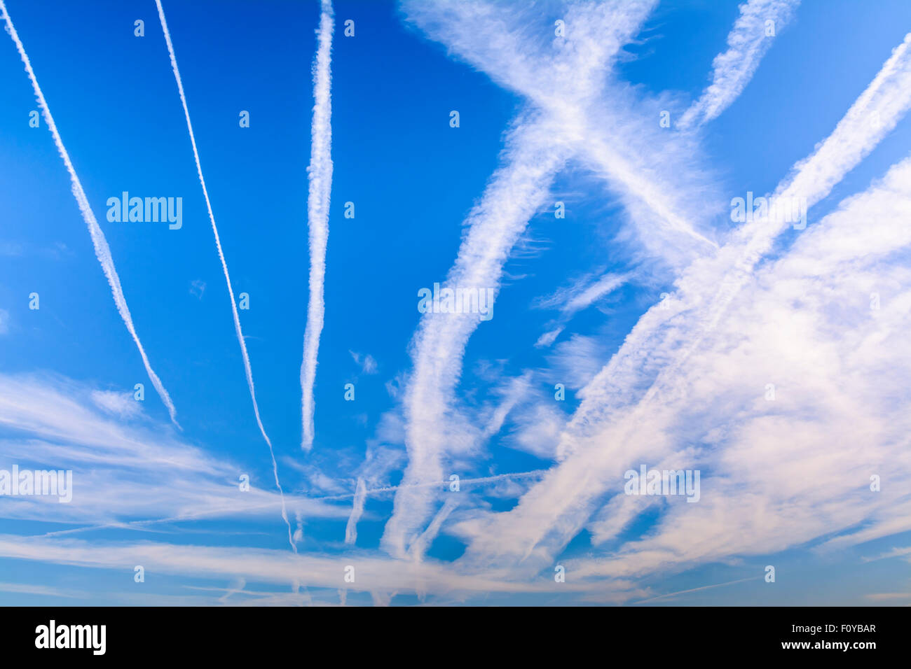 Condensation vapour trails (contrails) from jet engines on aircraft, in blue sky. Aeroplanes or airplane pollution. Global warming. Stock Photo
