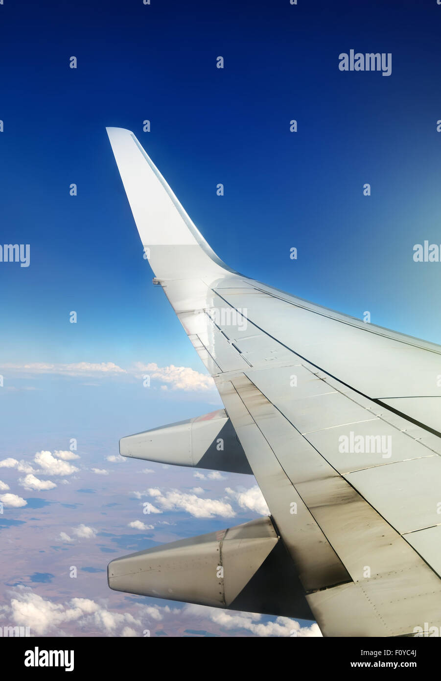 Wing of plane in sky and white clouds Stock Photo