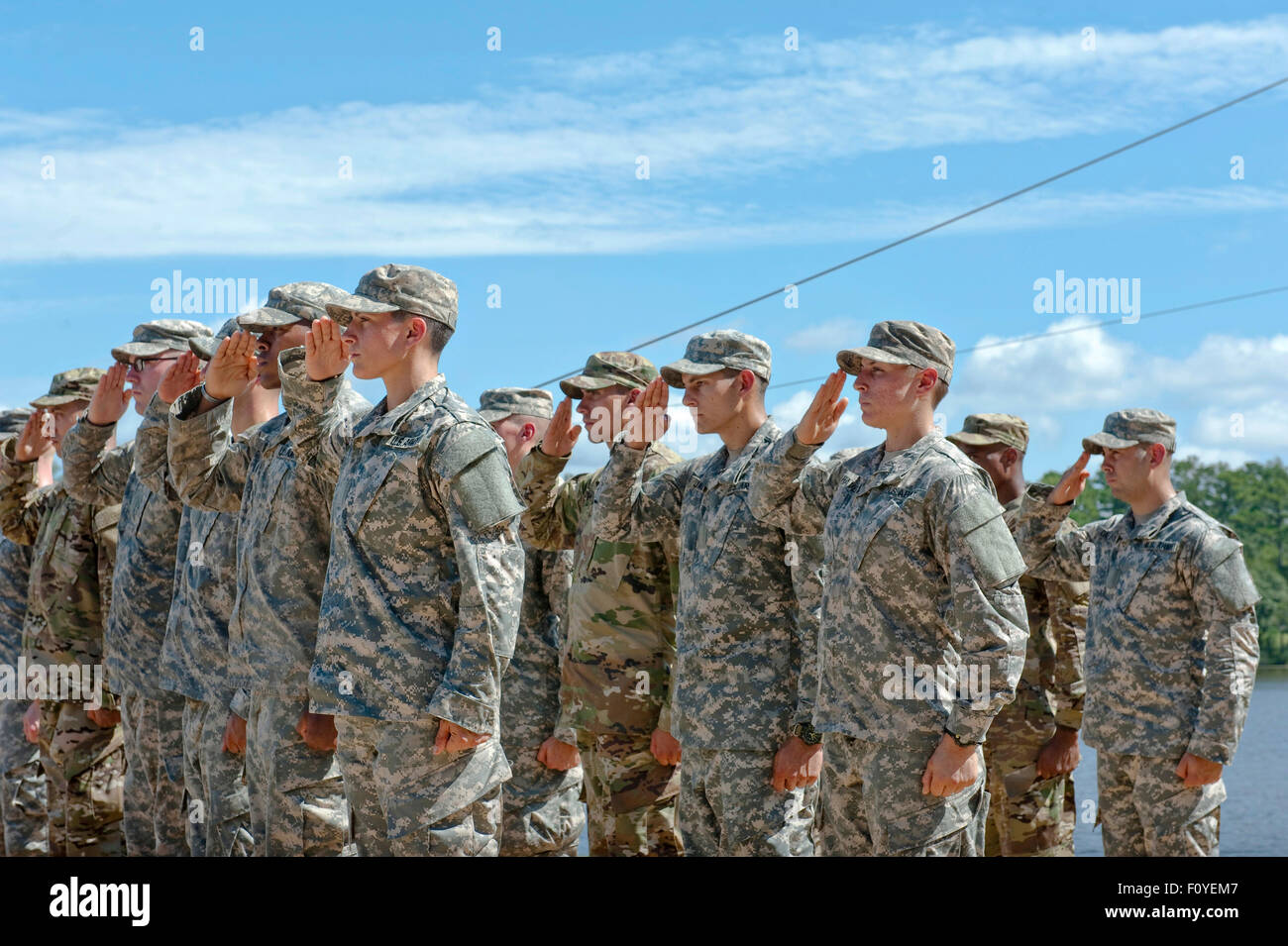 U.S. Army Captain Kristen Griest, left, and fellow soldier 1st Lt Shaye Haver, center, salute along with their class after becoming the first women to graduate from Army Ranger school August 21, 2015 at Fort Benning, Georgia. Stock Photo