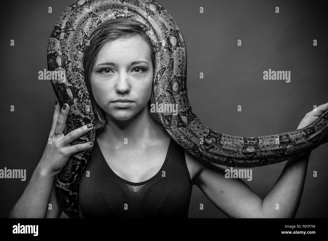 An intense looking staring young woman girl female person posing with a ...