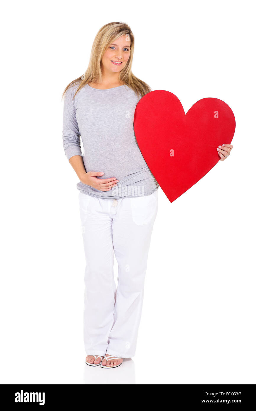 happy young pregnant woman holding red heart symbol Stock Photo