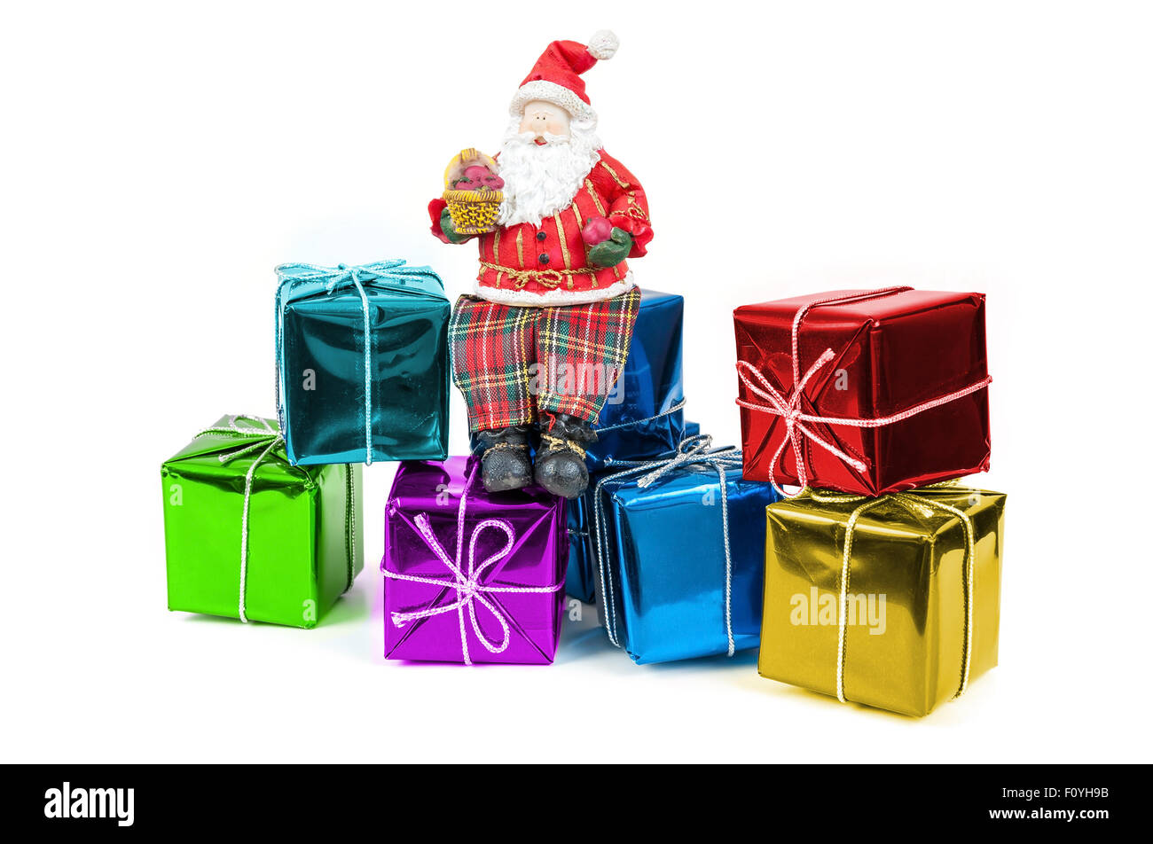 Santa Claus figure sitting on a colorful gift boxes isolated on white ...