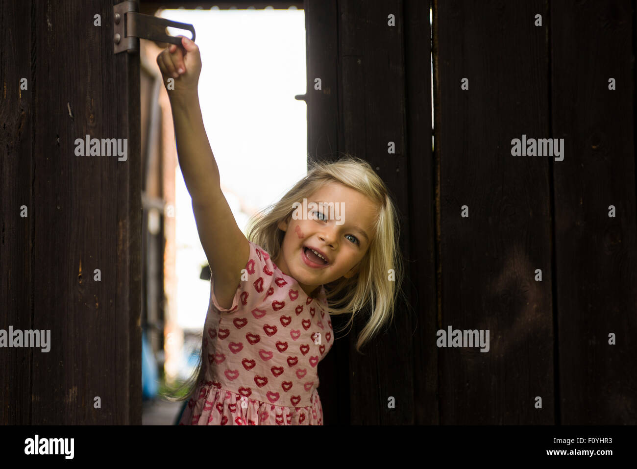 Child Blond Girl behind wooden gate, looking Stock Photo