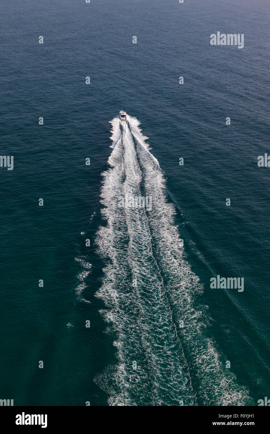 Small motor boat sailing in the middle of a deep ocean Stock Photo