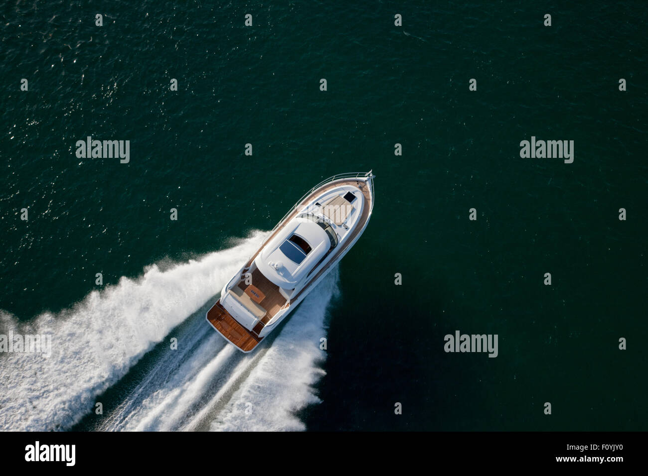 White speed boat sailing through a deep green sea Stock Photo - Alamy