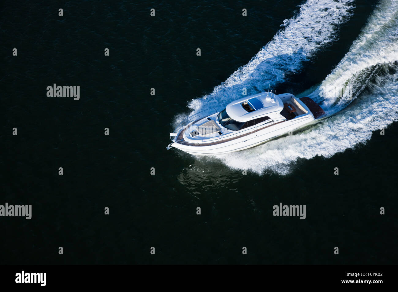 A beautiful white speed boat sailing in a dark sea Stock Photo - Alamy