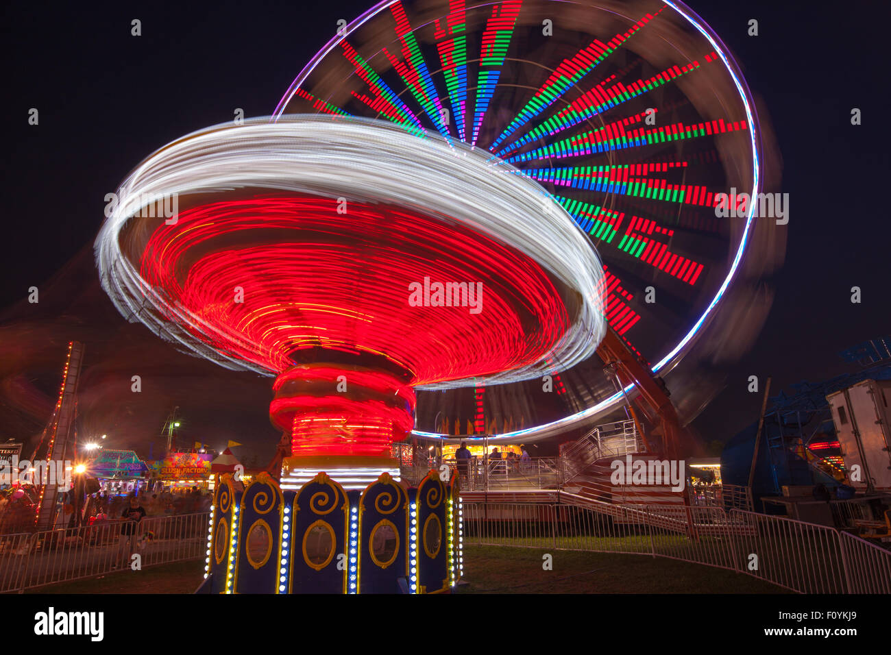 Colorfully illuminated rides spin against the night sky during the New