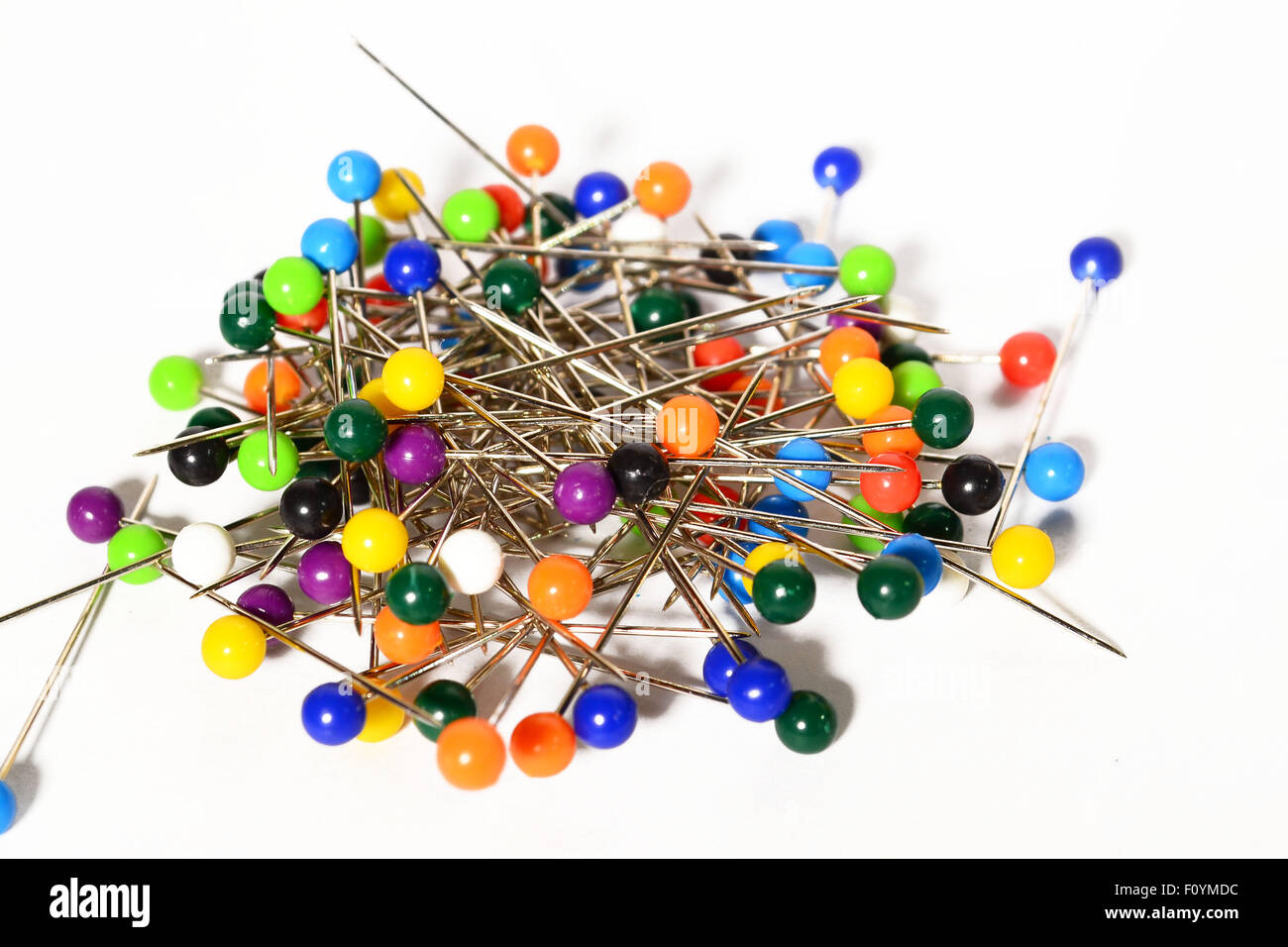 Heap of multi-coloured sewing pins on a white background, Stock image