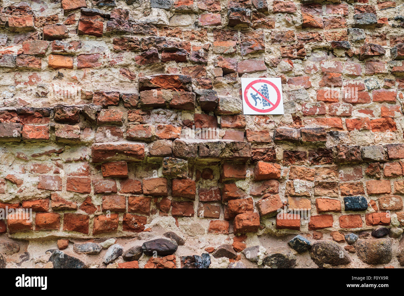No climbing sign on old insecure wall Stock Photo