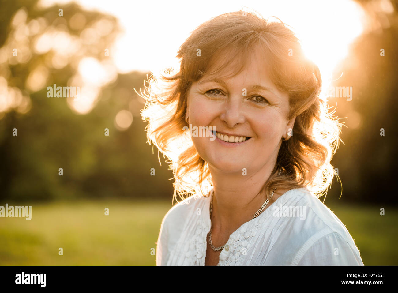Outdoor portrait of mature woman - in nature at sunset Stock Photo