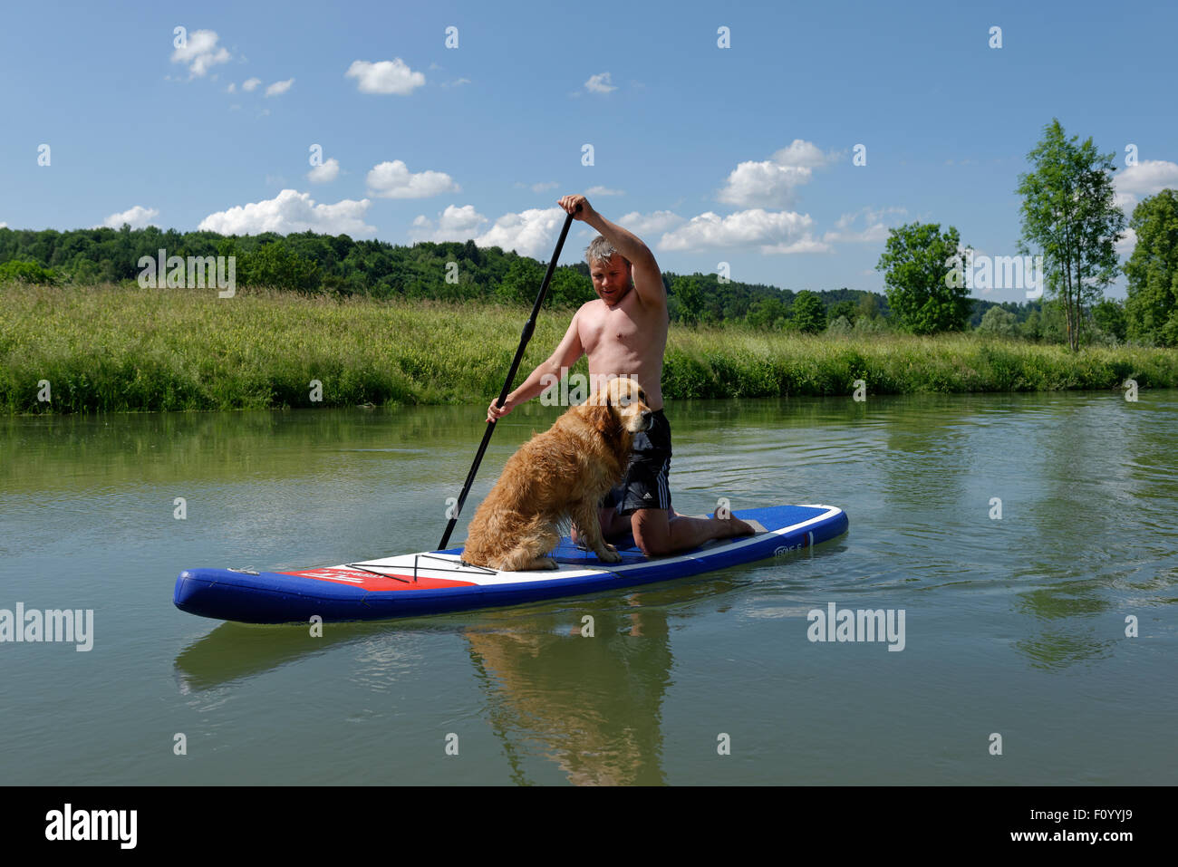 Man with his dog on a stand up paddle board, SUP, paddle boarding