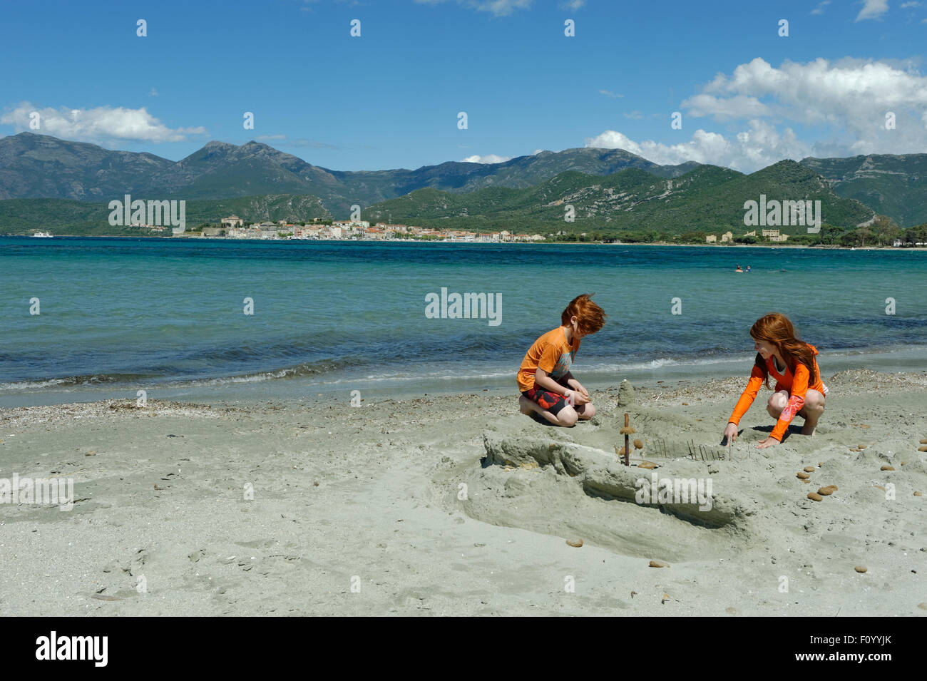 Children Playing On The Beach And Bay Of Saint Florent
