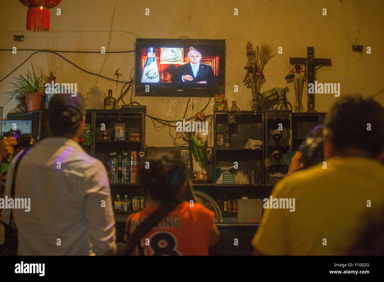 (150824) -- GUATEMALA CITY, Aug. 24, 2015 (Xinhua) -- People watch TV as Guatemala's President Otto Perez Molina delivering a speech, in Guatemala City, capital of Guatemala, on Aug. 23, 2015. President Otto Perez Molina says he won't resign from office despite investigators saying he may have been involved in a customs fraud scandal that has thrown the country into political crisis. (Xinhua/Luis Echeverria) Stock Photo
