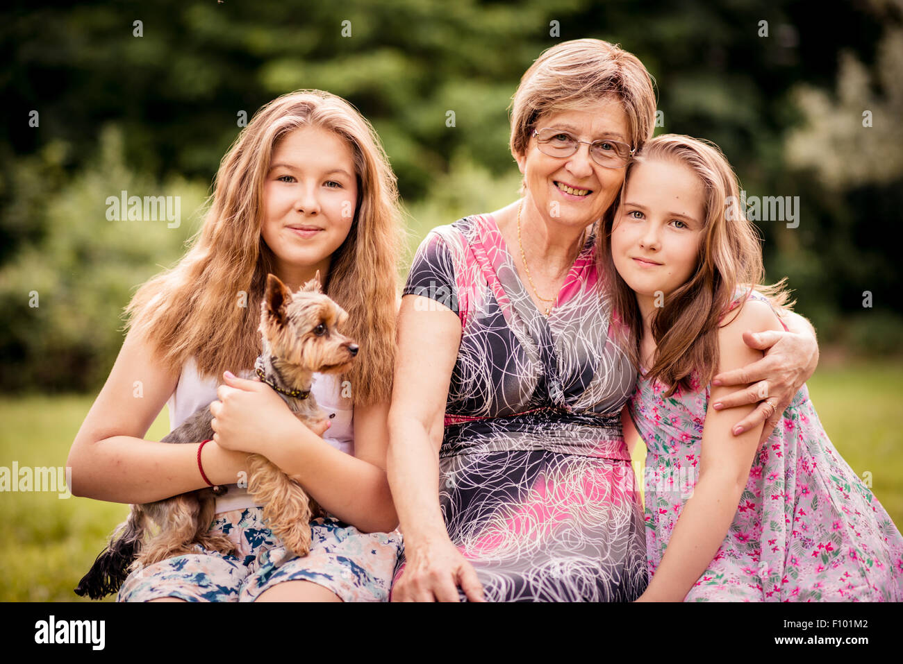 Portrait of grandmother with grandchildren and dog - outdoor in nature Stock Photo