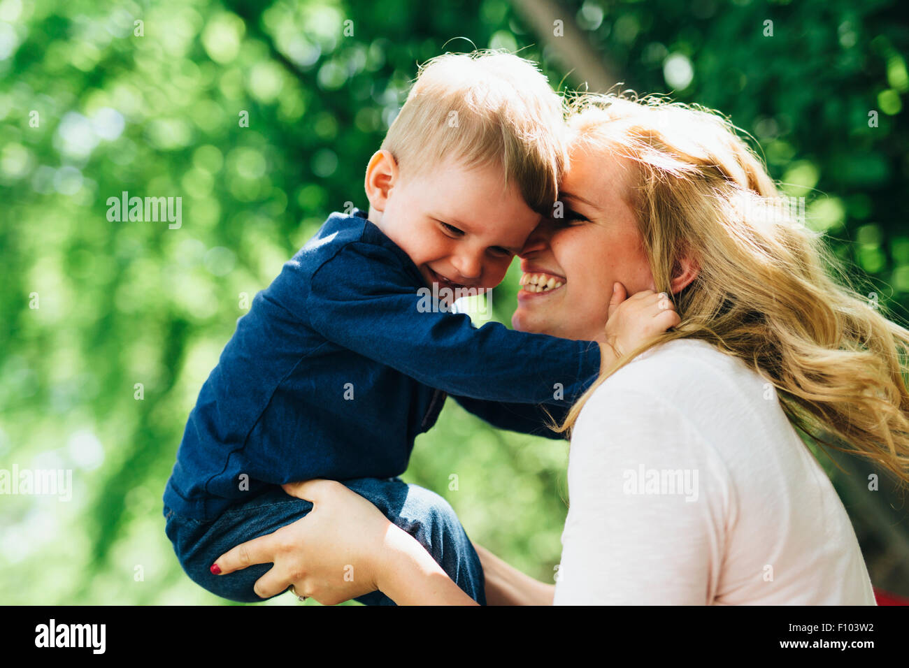 Mother smiling laughing and playing with her child outdoors on a nice summer day Stock Photo