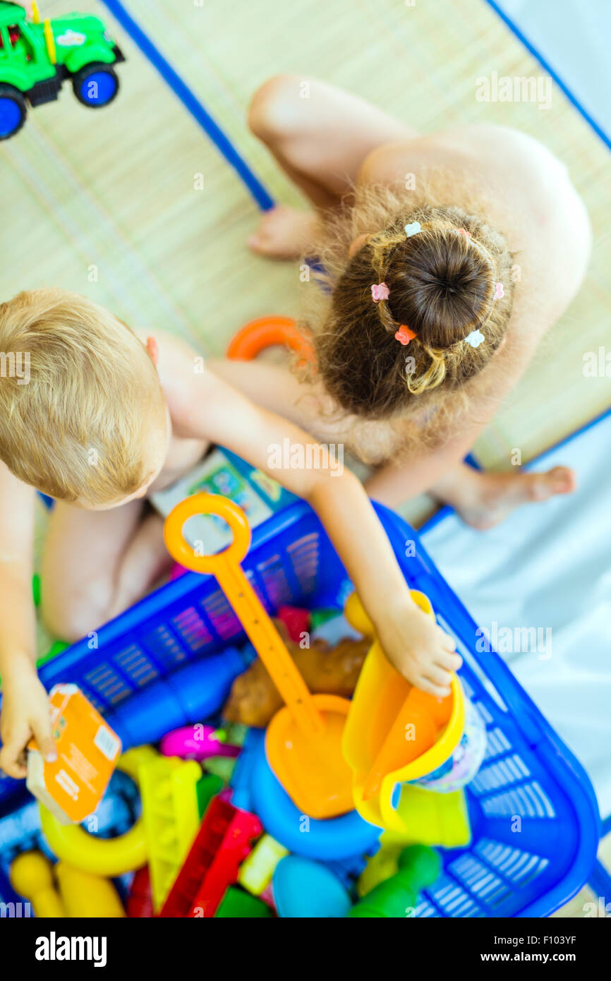 Beautiful young children playing with plastic toys outdoor Stock Photo