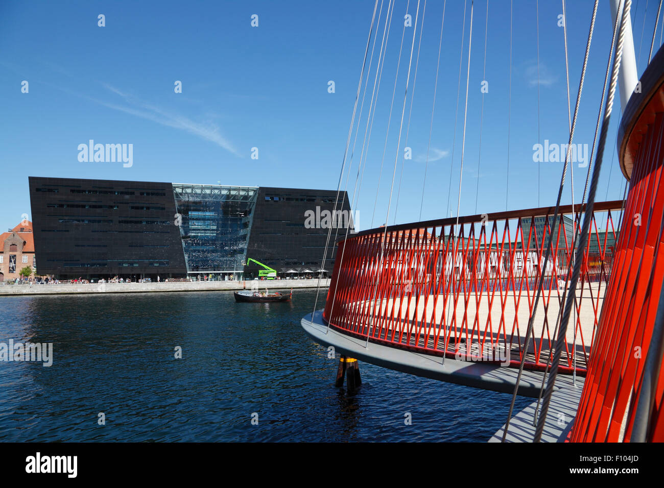 Cirkelbroen, the Circle Bridge, designed by Olafur Eliasson spanning Christianshavn Canal. The Black Diamond, Den Sorte Diamant, in the background. Stock Photo
