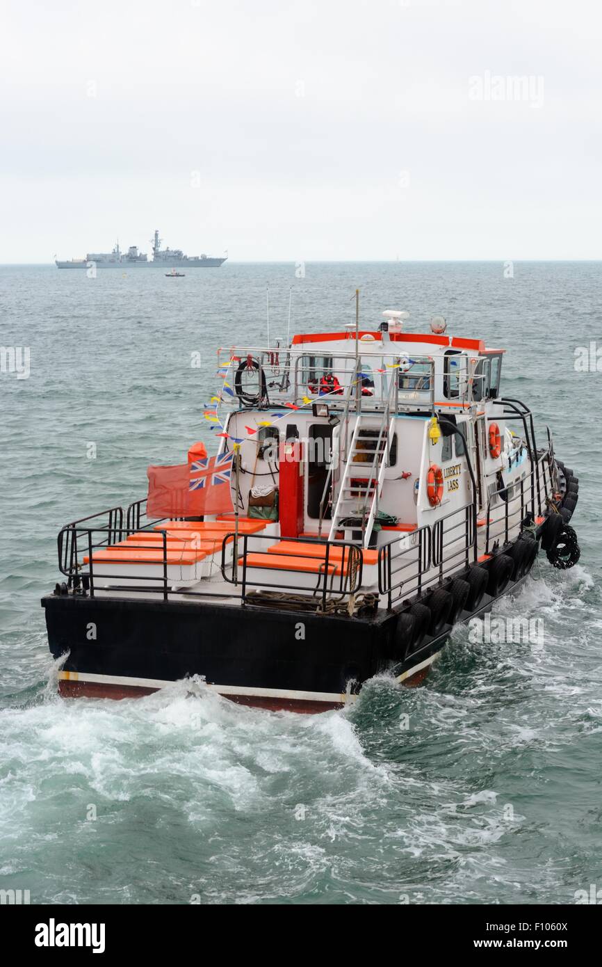 MV Liberty Lass transfer boat transits between Bournemouth Pier and Royal Navy frigate HMS Iron Duke F234 at the 2015 air show. Stock Photo