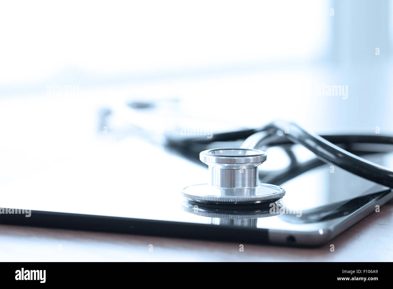 Stethoscope with digital tablet computer on wooden table and background ...
