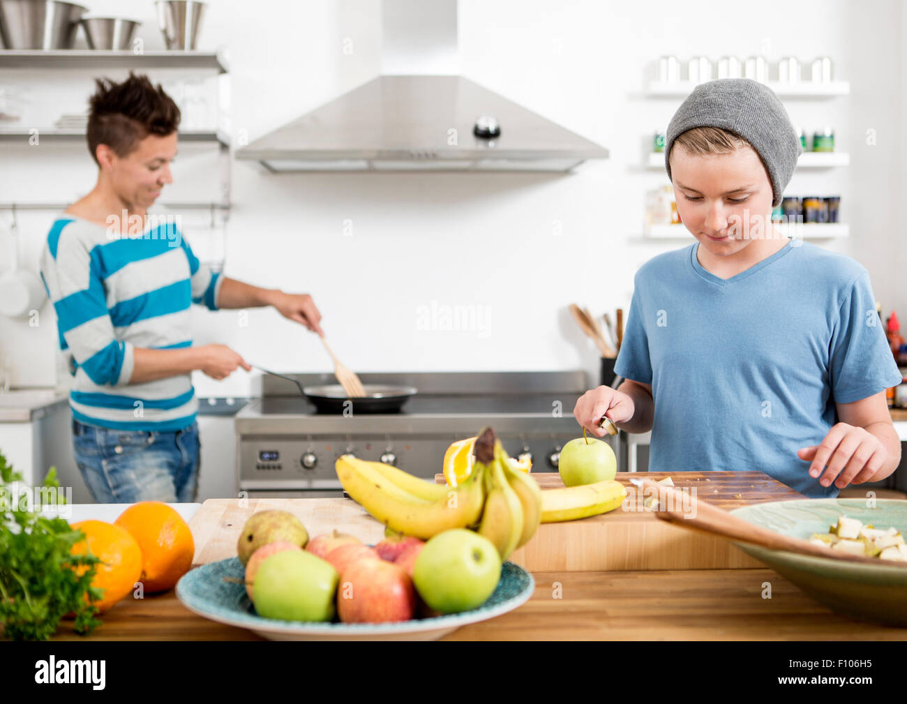 Mother and son in the kitchen preparing food together Stock Photo