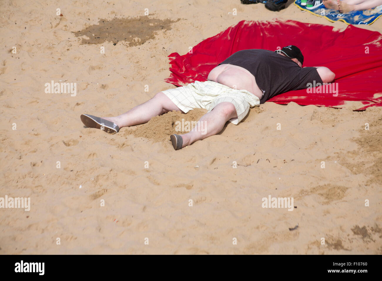 Male enjoying the hot sunny day sunshine at Bournemouth beach in August Stock Photo