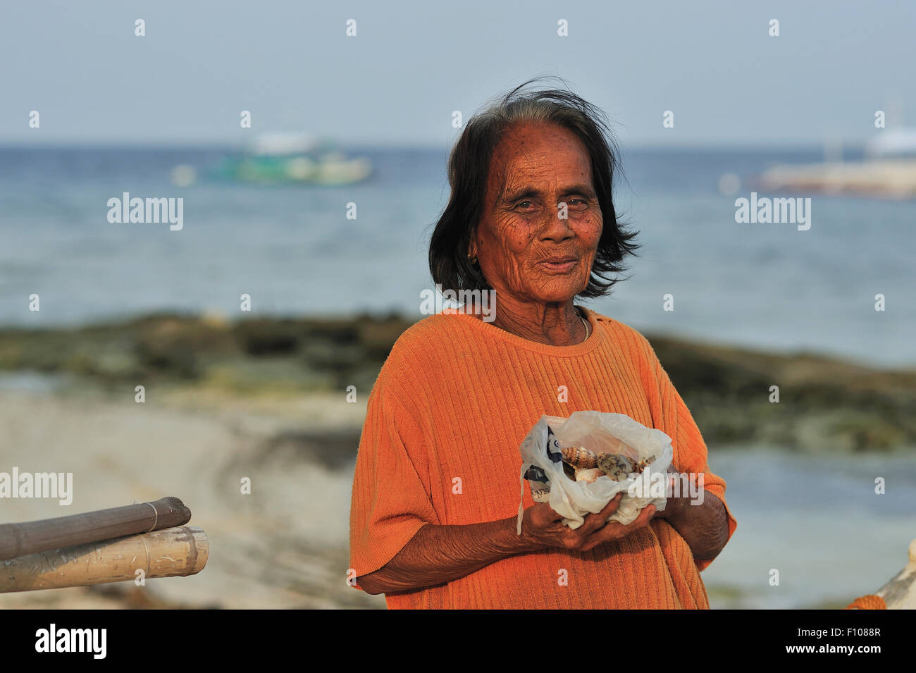 Elderly filipina selling shells on Panagsama Beach Moalboal Philippines Stock Photo