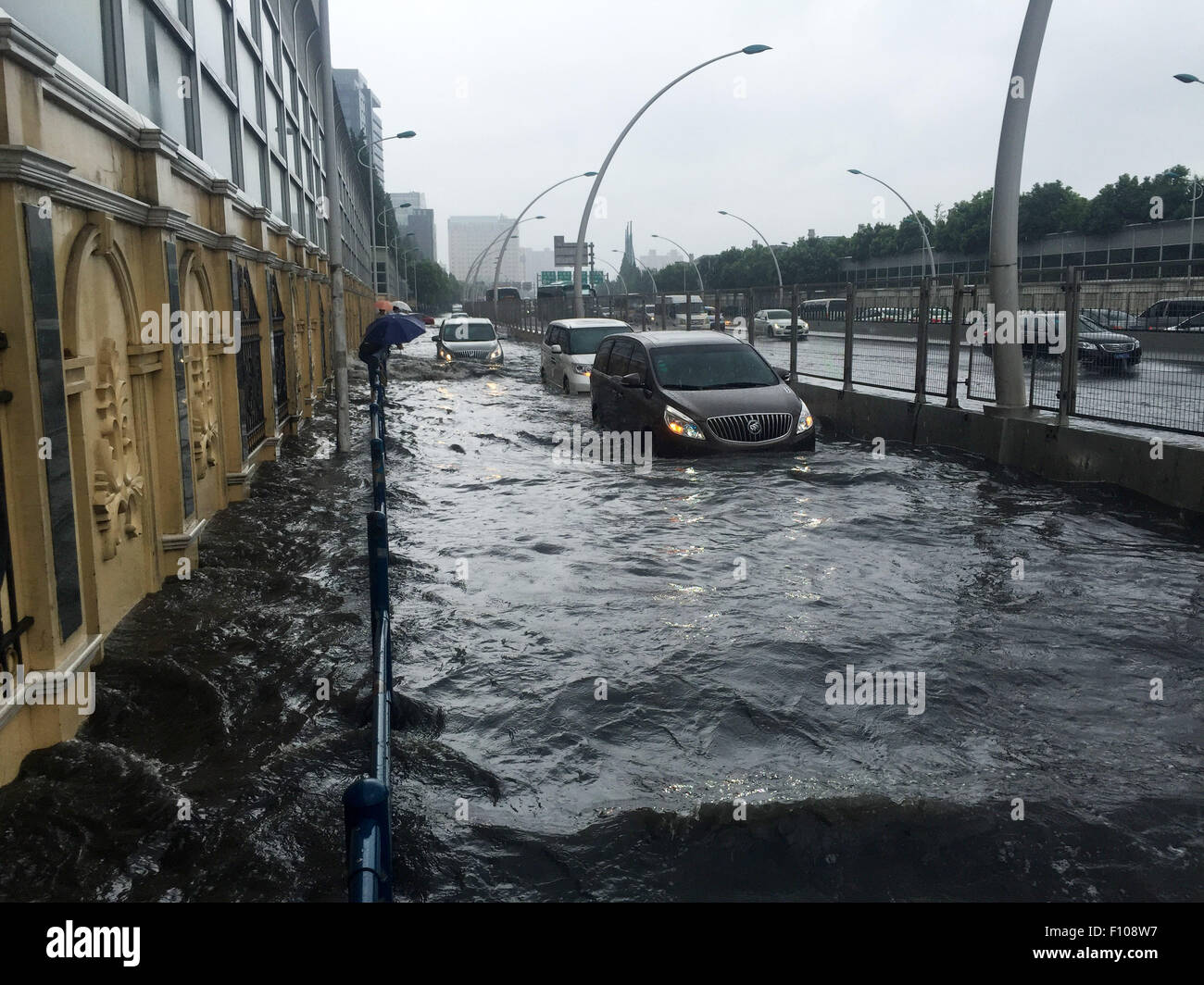 Shanghai. 24th Aug, 2015. Cars run on a waterlogged road in east China's Shanghai, Aug. 24, 2015. Shanghai witnessed gales and rainstorms since Sunday night under the influence of the approaching typhoon Swan. Credit:  Zhao Yun/Xinhua/Alamy Live News Stock Photo