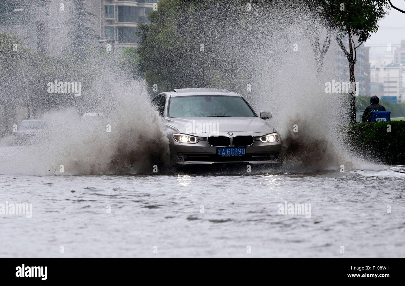 Shanghai. 24th Aug, 2015. A car runs on a waterlogged road in east China's Shanghai, Aug. 24, 2015. Shanghai witnessed gales and rainstorms since Sunday night under the influence of the approaching typhoon Swan. Credit:  Zhao Yun/Xinhua/Alamy Live News Stock Photo