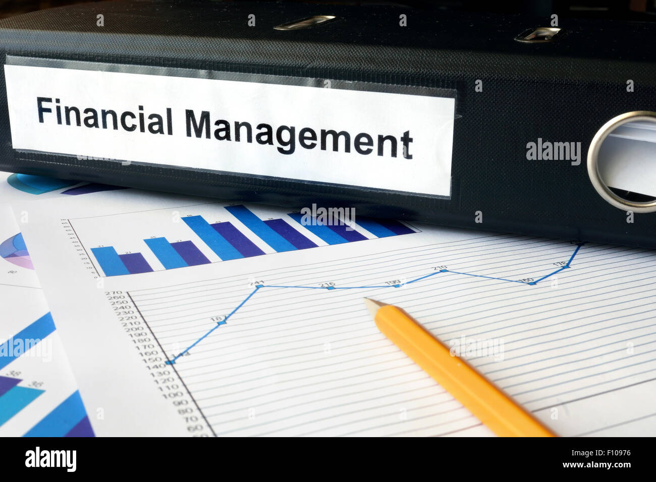 Graphs and file folder with label Financial Management. Business concept. Stock Photo