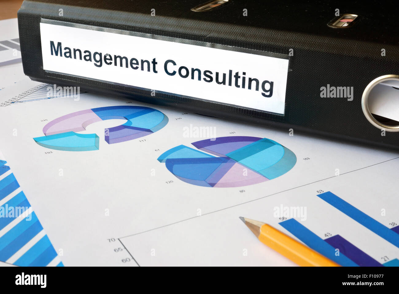 Graphs and file folder with label Management Consulting. Business concept. Stock Photo