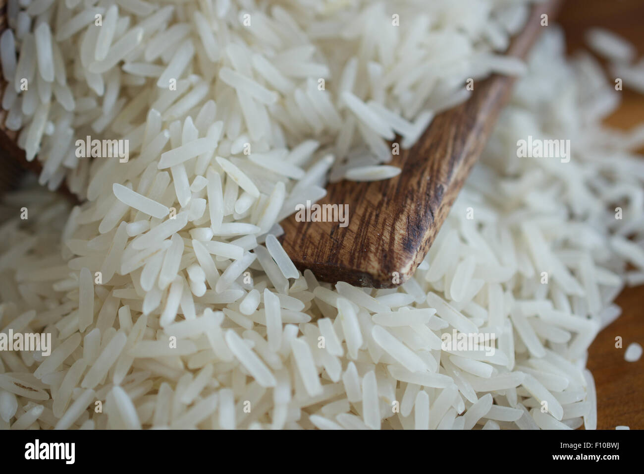 Long grain rice and wooden scoop Stock Photo Alamy