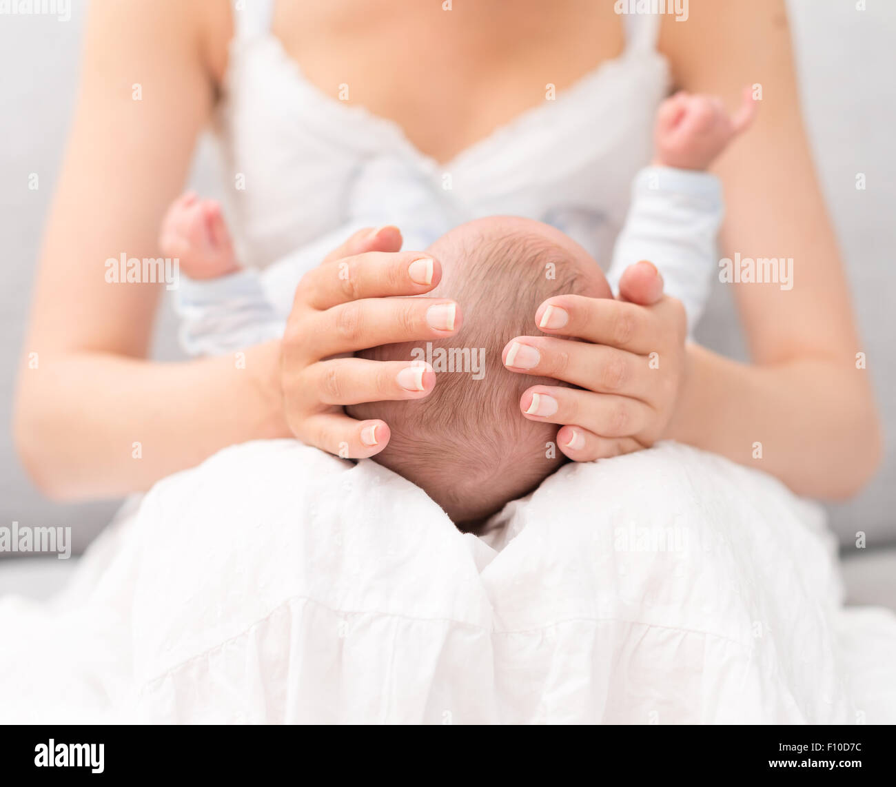 Mother is holding newborn baby on her knees Stock Photo Alamy