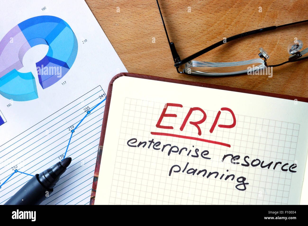 Notepad with Enterprise Resource Planning System (ERP) on office wooden table. Stock Photo
